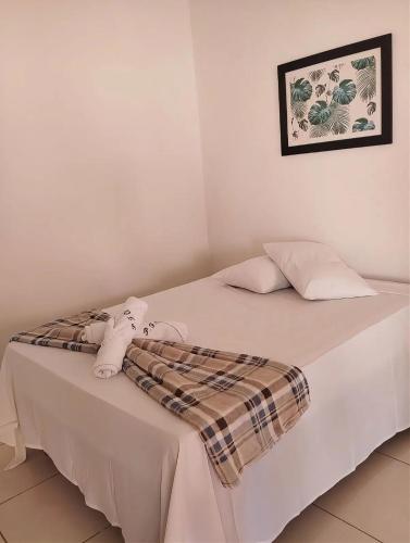 a white bed with a blanket and stuffed animals on it at Fonte dos Corais - Suíte Lua na Praia in Maragogi
