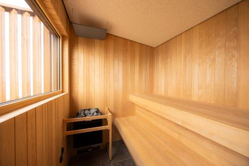 eine Sauna mit Holzwänden und einem Fenster in der Unterkunft the SHIHACHI 