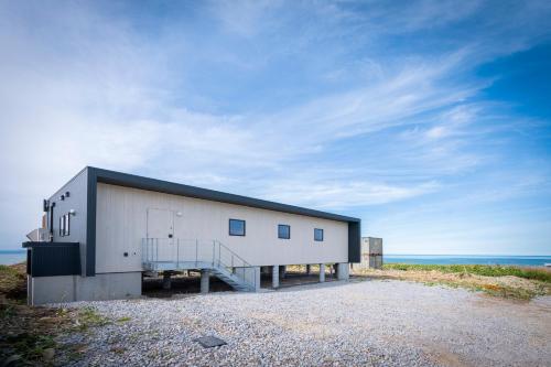a building on the beach with the ocean behind it at the SHIHACHI 