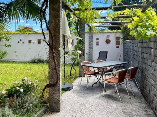 a patio with a table and chairs in a garden at 1,5 Zimmer Ferienwohnung in Luzern