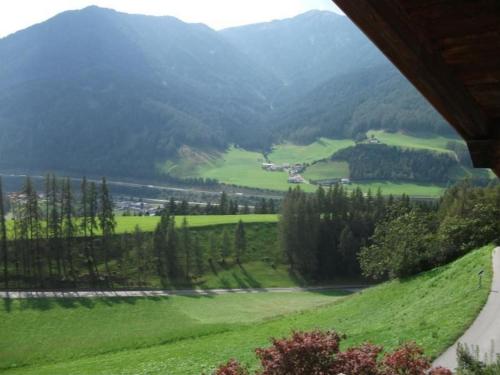 a view of a green field with mountains in the background at Ferienhaus In Ruhiger Lage Am Waldrand in Navis