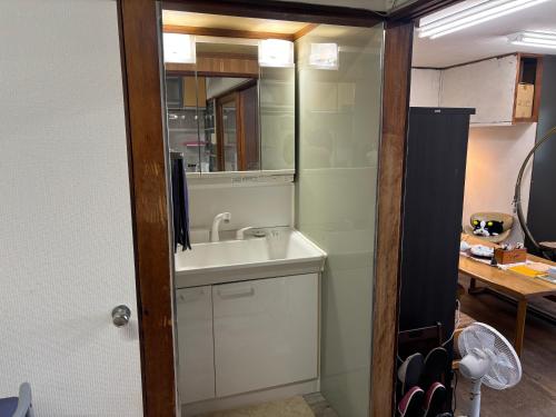 a bathroom with a sink and a mirror at hamanocho Ap in Shimminatomachi