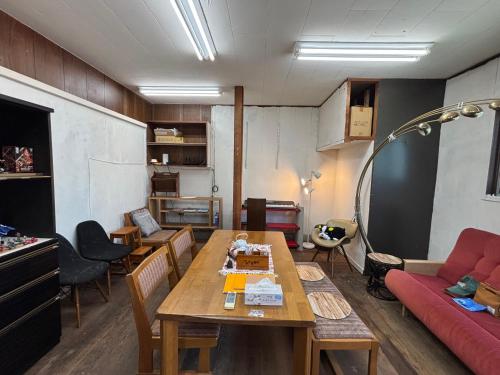 a living room with a table and a red couch at hamanocho Ap in Shimminatomachi