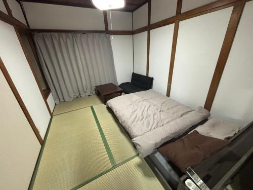 a small room with a bed and a chair at hamanocho Ap in Shimminatomachi
