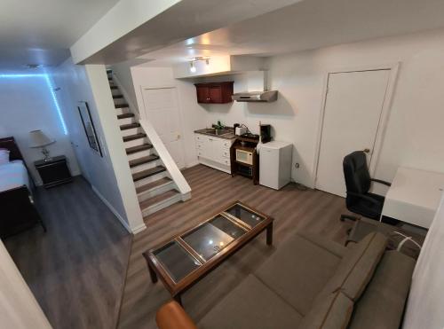 a living room with a couch and a table and a kitchen at Cozy Bachelor Apartment at Trillium in Kingston