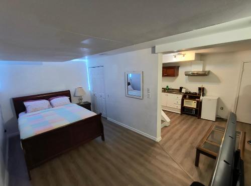 ein kleines Schlafzimmer mit einem Bett und einer Küche in der Unterkunft Cozy Bachelor Apartment at Trillium in Kingston