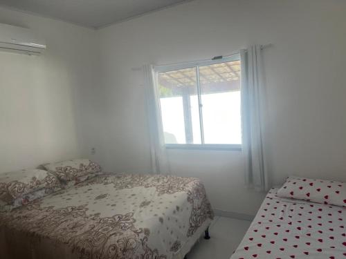 ein Schlafzimmer mit einem Bett und einem Fenster in der Unterkunft CONDOMINIO MERIDIEN PRAIA MAR Praia do Abais in Estância