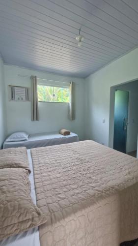 a bedroom with two beds and a window at Casa do Pepe em Barra de Jacuípe in Camaçari