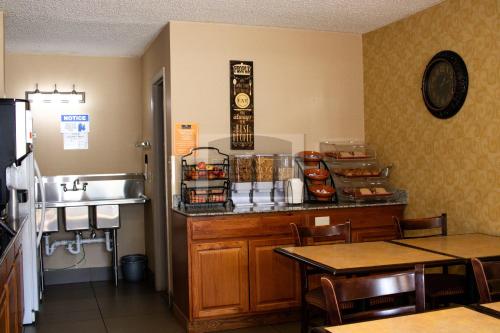 a restaurant with a counter with a sink and a table at Brentwood inn & Suites - Lynchburg in Lynchburg
