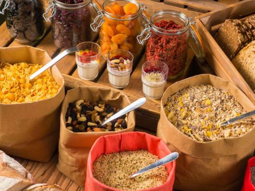 una mesa cubierta con recipientes de diferentes tipos de alimentos en ibis Birmingham Airport Terminal Building - NEC, en Bickenhill