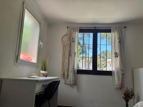 Zimmer mit einem Schreibtisch und einem Fenster mit einem Schreibtisch und einem Schreibtisch. in der Unterkunft Cabaña LAS PALMAS dos dormitorios in Santa Clara del Mar