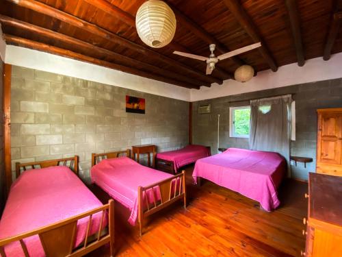 two beds in a room with pink sheets at Cabañas El Nogal in Villa Anizacate