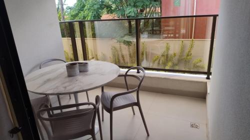 a table and two chairs and a table and a window at Apartamento à beira-mar em São Miguel do Gostoso in São Miguel do Gostoso
