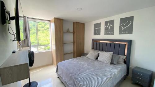 ein Schlafzimmer mit einem Bett und einem Fenster in der Unterkunft Apartamento en San Gil, in San Gil