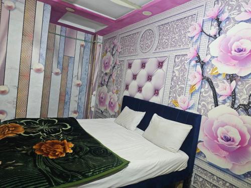 Un dormitorio con una cama con flores en la pared. en City Palace Hotel Lahore, en Lahore