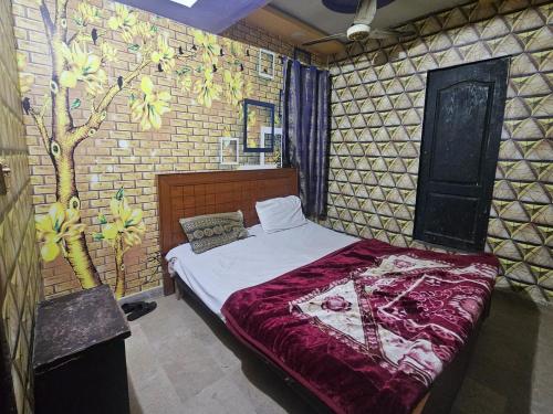 1 dormitorio con 1 cama con un mural en la pared en City Palace Hotel Lahore, en Lahore