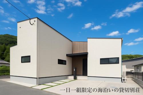 a white house with a black roof at 海沿いの1日1組限定の貸切別荘 Smile Itoshima Stay in Itoshima