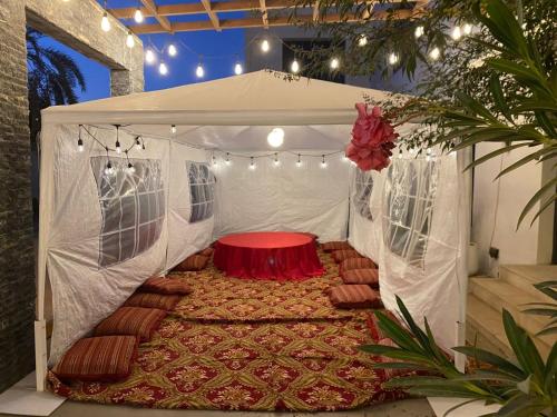a white tent with a red table in it at Lammah chalet in Muscat