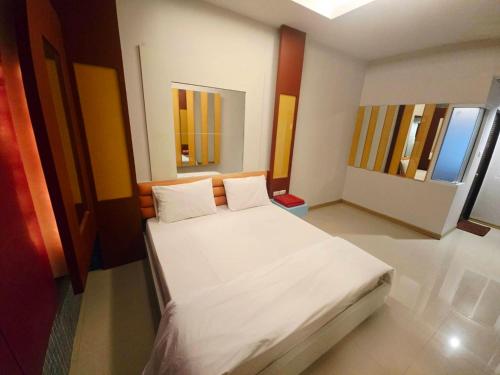 a bedroom with a white bed with two windows at Save Hotel เซฟ โฮเทล 