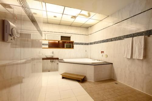 a bathroom with a tub and a sink and a toilet at Treasure Island Motel - Fengshan in Kaohsiung