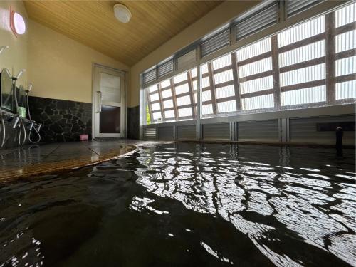 an empty room with a pool of water in a building at Chalet Nozawa in Nozawa Onsen