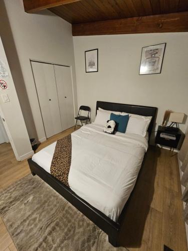 a bed with a stuffed animal sitting on top of it at P&N Suites - Queen Room- DUBAI in Edmonton