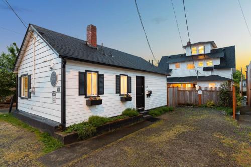 ein weißes Haus mit schwarzen Fensterläden und ein Gebäude in der Unterkunft Home & Carriage House Views Dogs Welcome BBQ in Edmonds