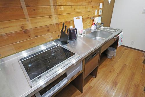 a kitchen with a stove top oven next to a sink at Laina Minoh Makiochi in Minoo