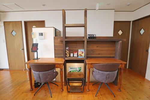 a room with a desk and a shelf and two chairs at Laina Minoh Makiochi in Minoo