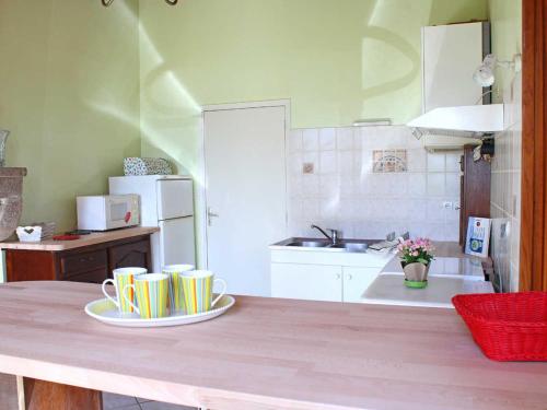 una cocina con una mesa con dos tazas. en Gîte lumineux avec jardin, draps inclus, près de Vichy - FR-1-489-281, en Trézelles