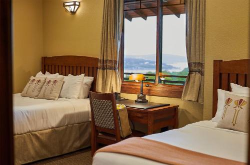 a hotel room with two beds and a desk with a window at Hilton Grand Vacations Club Long Creek Ridgedale in Ridgedale