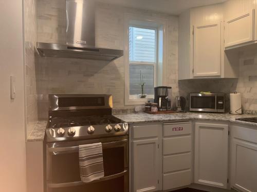 una cocina con estufa y microondas en Two fully independent unit - a modern house and a private apartment, each with its own entrance, located just 15 min from Sea-Tac Airport and 5 min from Des Moines Marina, en Des Moines