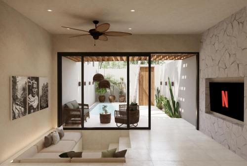 a living room with a couch and a ceiling fan at New Luxury Ribamar Villas in Uluwatu