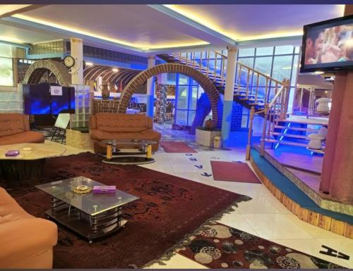 a living room with couches and a tv and stairs at Kabul Blue Star Guest House in Deh Sabz