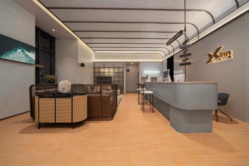 a lobby with a reception desk and a bar at Dahua Group Xinn Hotel (Haikou West Coast Convention & Exhibition Center Branch) in Zhenhai