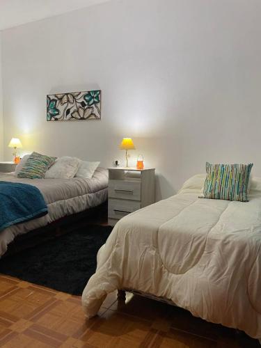 a bedroom with two beds and a desk with a lamp at Sol de Mayo in Tinogasta