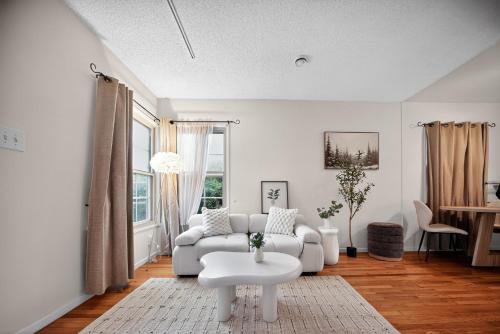 ein weißes Wohnzimmer mit einer Couch und einem Tisch in der Unterkunft Cozy Comfort Stylish 2BR 1BA near LAX, LMU, SoFi Stadium & Beaches in Los Angeles
