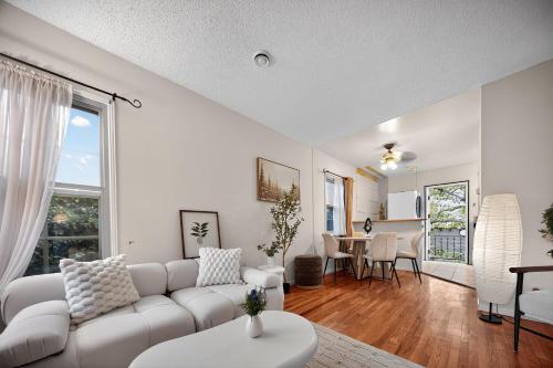 ein Wohnzimmer mit einer weißen Couch und einem Tisch in der Unterkunft Cozy Comfort Stylish 2BR 1BA near LAX, LMU, SoFi Stadium & Beaches in Los Angeles