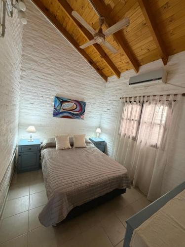 a bedroom with a bed and two tables and a ceiling at ElCapullo - Paso de la Patria in Paso de la Patria