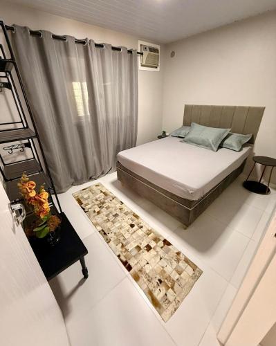 a bedroom with a bed and a rug at Casa charmosa praia Itapema in Itapema