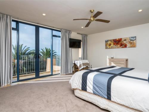 a bedroom with a bed and a large window at La Belle Maison - Ruakaka Holiday Apartment in Ruakaka