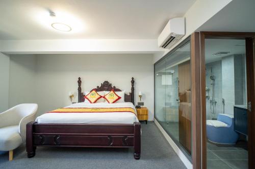 a bedroom with a bed and a shower and a tub at Palado Hotel Mui Ne in Ấp Thiện Phước