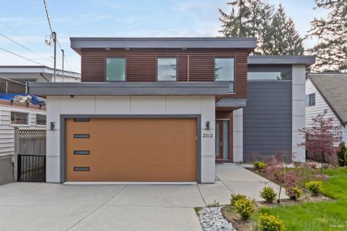 a house with a brown garage door at Modern 2Bed Suite Near Capilano Bridge & Trails in North Vancouver