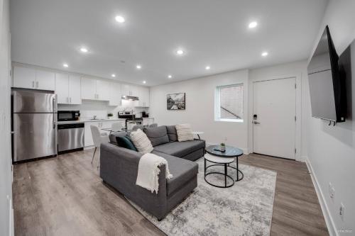 a living room with a couch and a kitchen at Modern 2Bed Suite Near Capilano Bridge & Trails in North Vancouver
