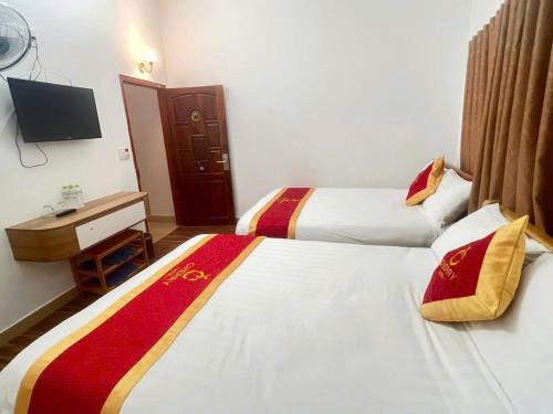 a hotel room with two beds and a television at CHERRY HOTEL in Da Lat