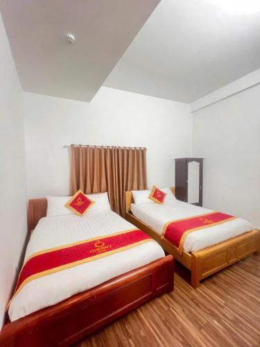 two beds sitting in a room with at CHERRY HOTEL in Da Lat