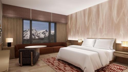 a bedroom with a large white bed and a couch at Hilton Altay Hemu in K'u-mu