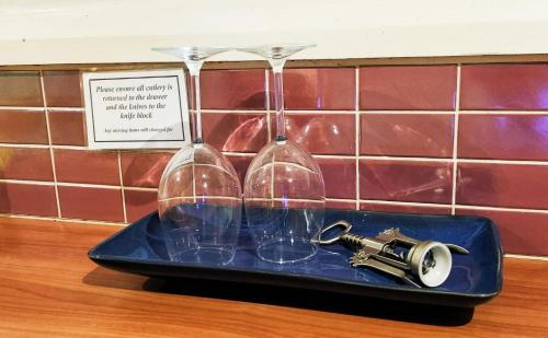 zwei Weingläser auf einem Tablett auf einer Theke in der Unterkunft Redruth - 2 bedroom cottage situated in wandiligong in Wandiligong