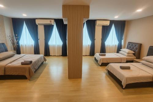 Dos camas en una habitación con cortinas azules. en Arlyn's Homestay, en Sandakan