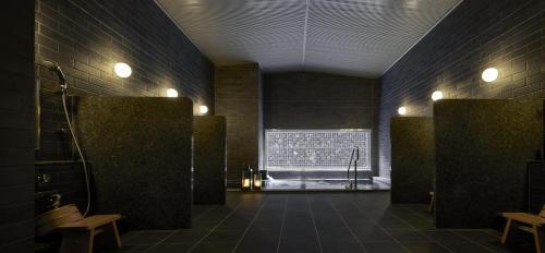 a room with a bathroom with a shower and a window at Hinode Hills Niseko Village in Niseko